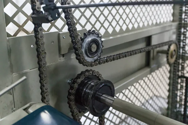 Triple strand roller chain going around three sprockets on industrial machine. the chain drive shaft Line Conveyor Industrial