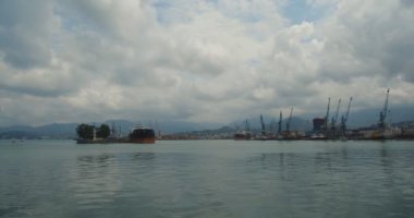 Yerel bağlantı noktası demirli Tanker ile manzara. Bir deniz feneri ve bir iskele sonunu ağaçta. Acara, Gürcistan