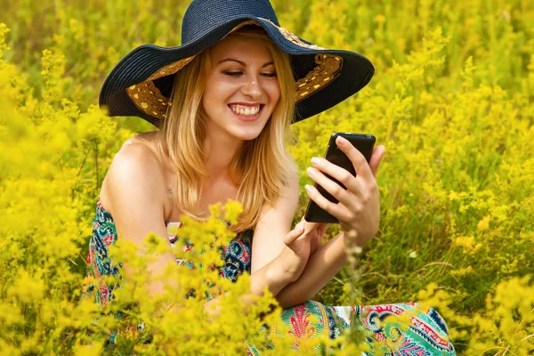 Flicka i fältet med telefon. — Stockfoto