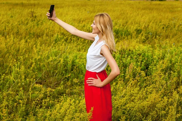 Flicka i fältet med telefon. — Stockfoto