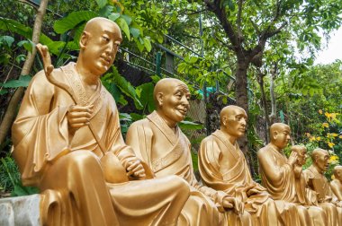 Önde gelen on bin Buda Manastırı ve manzara merdiven boyunca altın Buda heykelleri ile Hong Kong arka planda yeşil ağaçlar. Hong Kong Asya'nın popüler turistik yer.