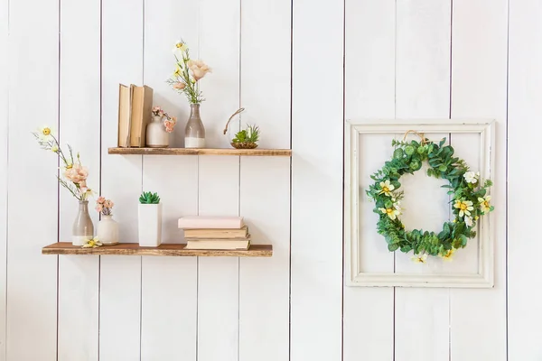 wooden shelves with books and flowers on the wall