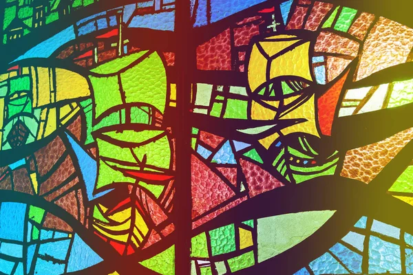 Image of a multi-colored stained-glass window with an abstract pattern. Stained glass window