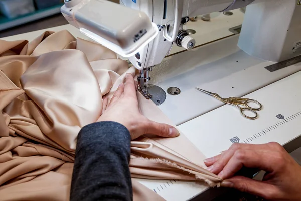 Mujer cose tela por una máquina de coser — Foto de Stock