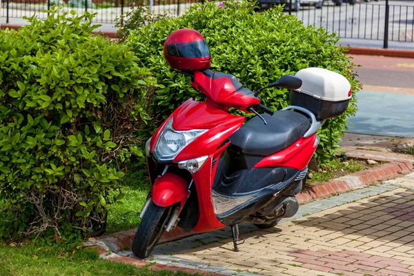 En röd skoter står parkerad på en tom gata. — Stockfoto