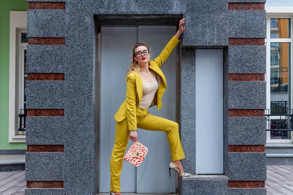 Элегантная женщина в жёлтом костюме возле лифта — стоковое фото