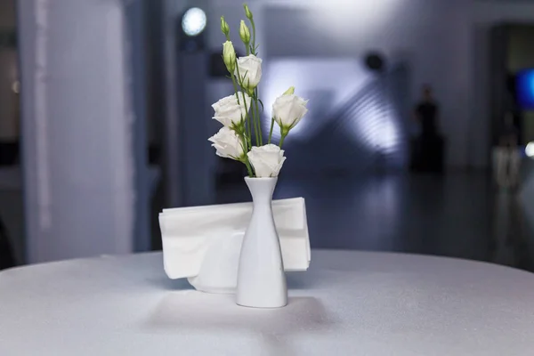 The table decor with a white vase and white roses — 스톡 사진