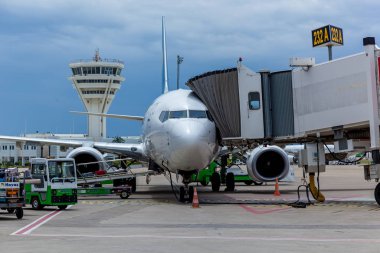 Jet köprüsünün yanında yolcu bekleyen bir uçak.