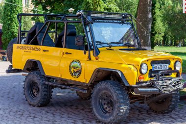 Parka park etmiş sarı bir Jeep Wrangler.