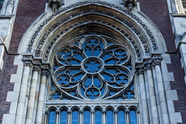 An ancient iron window with decorative elements on the facade of a church — Stock Photo, Image