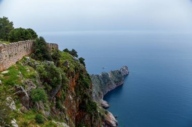 Bir denizin arka planındaki Alanya kalesinin antik kalıntılarının güzel bir manzarası..