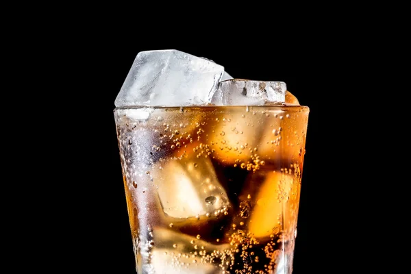 Corriente de soda que se vierte en un vaso con soda y cubo de hielo sobre fondo negro, textura de primer plano, salpicaduras, salpicaduras, fizz —  Fotos de Stock