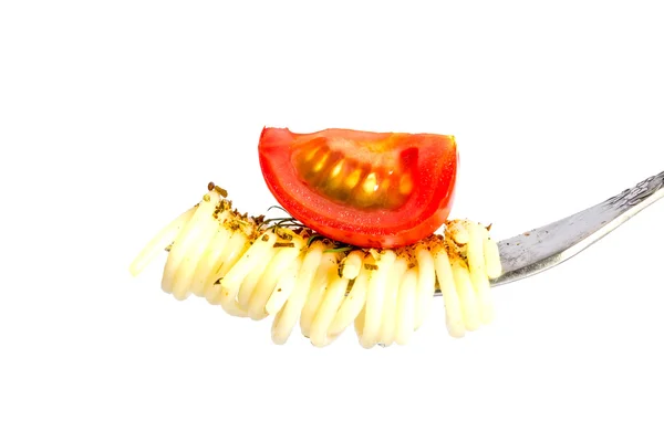 Massa de espaguete com manjericão e um ramo de vegetação ferida em um garfo com um pedaço de tomate cereja isolado no fundo branco — Fotografia de Stock