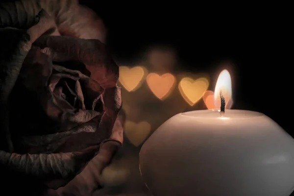 Candle with rose flower on bokeh hearts background. Vintage style. — Stock Photo, Image