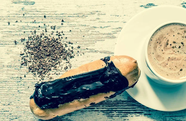 Café, pastel, eclair con chispas de chocolate de cerca sobre fondo de madera vintage. Vista superior. Estilo vintage . — Foto de Stock