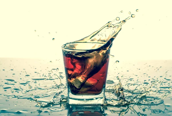 Splashing in glass with soda, ice cubes, white background. Old retro vintage style.