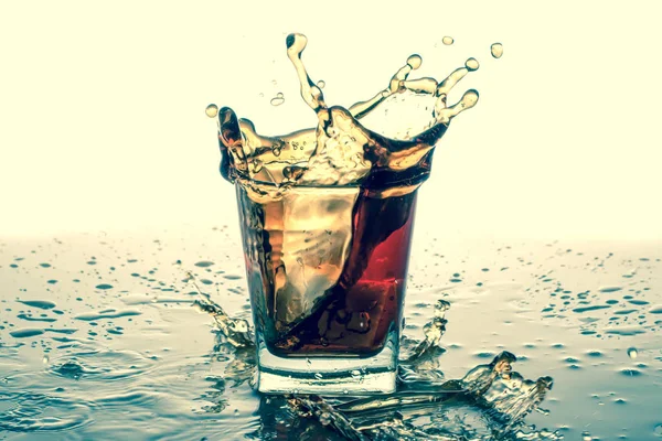 Splashing in glass with soda, ice cubes, white background. Old retro vintage style.