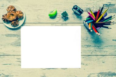 Çok renkli kalemler, bir beyaz kağıt eski stil saat, izole, renkli vintage bir ahşap zemin, ahşap üzerine pasta plaka kurulları çatlaklar ile giyilir. Eski retro vintage tarzı fotoğraf.