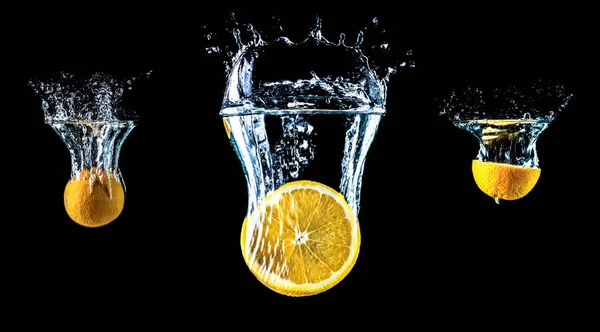 Composition of three oranges falling into water close-up, macro, splash water, bubbles, isolated, black background. Big large size. — Stock Photo, Image