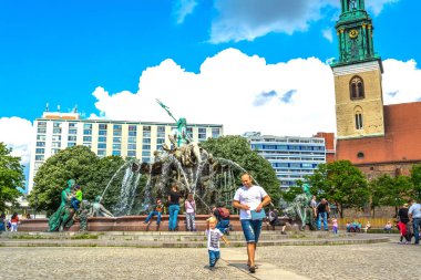 Berlin, Almanya - 25 Mayıs 2015: Berlin Neptün Çeşmesi. Bu Marienkirche Kilisesi ve kırmızı belediye arasında Berlin'in merkezinde yer alan. Güneşli bir gün, mavi gökyüzü, yeşil çiçek açan ağaçlar.