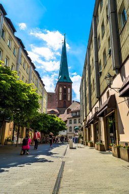 Berlin, Almanya - 25 Mayıs 2015: Aziz Nikolaos Kilisesi manzaralı Berlin'de Street. Tarihi çeyrek Nikolaiviertel yer. Güneşli bir gün, mavi gökyüzü, yeşil çiçek açan ağaçlar.