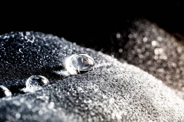 Gotas de água close-up macro em material de veludo com brilho solar — Fotografia de Stock