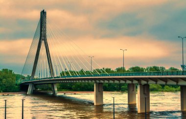 Modern köprüden nehrin yanında bir ayar güneş ile akşam Futbol Stadyumu Varşova