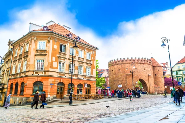 Варшава, Польша 07 мая 2017 года: Барбиканская крепость в Варшаве - укрепление XVI века, отделяющее Старый город от Нового города. Солнечный день с голубым небом и цветущей розовой вишней — стоковое фото