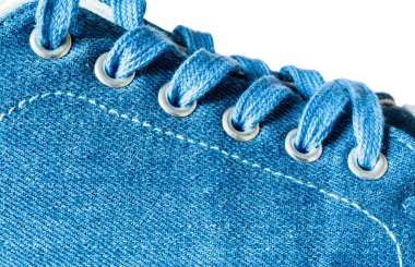 Beyaz arka plan üzerinde izole denim spor ayakkabı yakın çekim makro doku