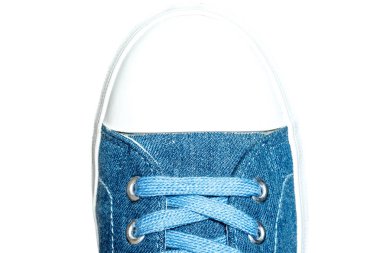 Beyaz arka plan üzerinde izole denim spor ayakkabı yakın çekim makro doku