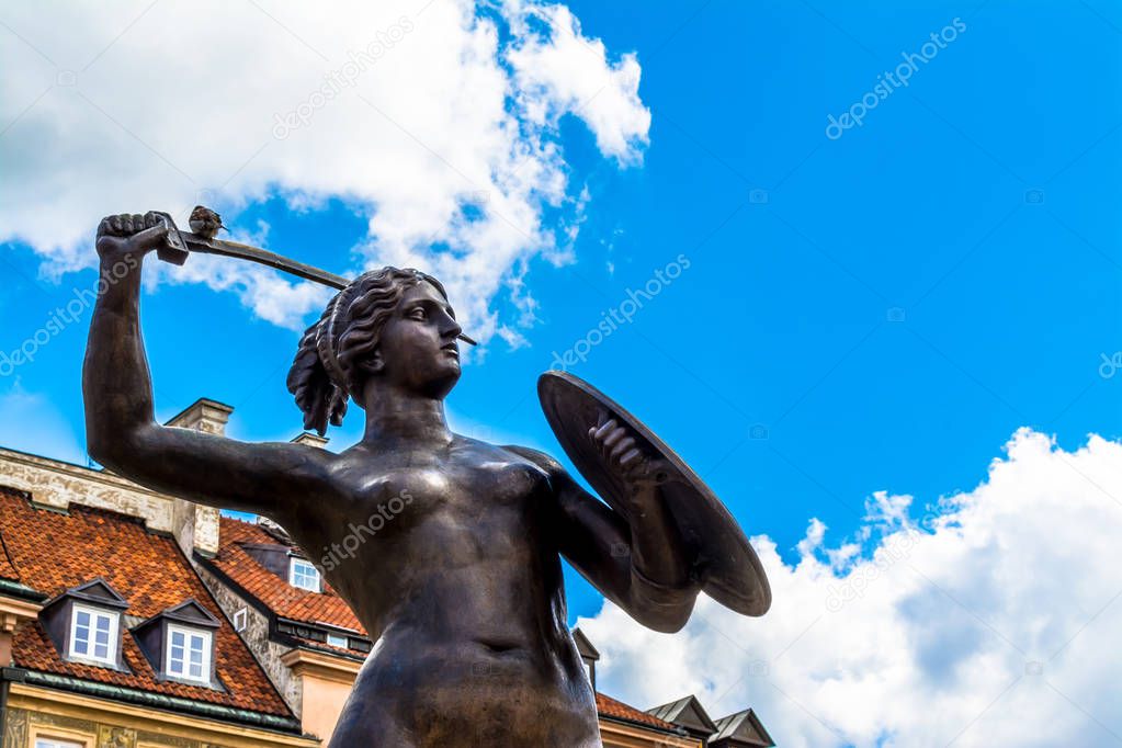 Warsaw, Poland  July 14, 2017: Sculpture of a mermaid in the old town in Warsaw on sunny day with blue cloudy sky.