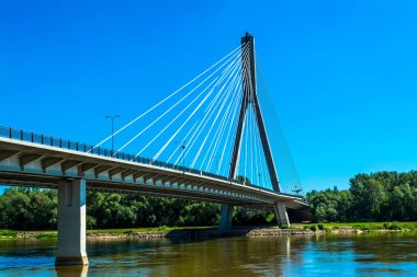 Varşova'daki modern köprü. Mavi bir gökyüzü ve yeşil ağaçları ile güneşli yaz günü. Yatay fotoğraf.