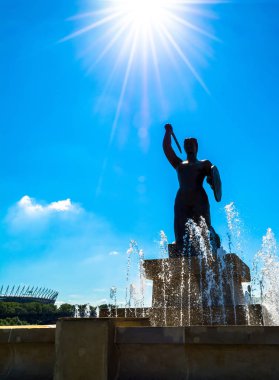 Varşova, Polonya 16 Temmuz 2017: Çeşmenin Varşova bir denizkızı heykeli. Mavi bir gökyüzü ve yeşil ağaçları ile güneşli yaz günü. Yatay fotoğraf.