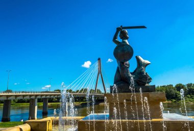 Varşova, Polonya 16 Temmuz 2017: Çeşmenin Varşova bir denizkızı heykeli. Mavi bir gökyüzü ve yeşil ağaçları ile güneşli yaz günü. Yatay fotoğraf.