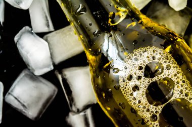 Şişe bira buz kabarcıkları ile karanlık bir arka plan üzerinde closeup cubes