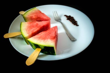 dondurma yakın çekim beyaz tabak çatal siyah bir arka plan ile bir sopa dilim karpuz kestim