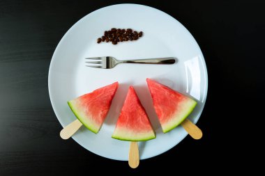 dondurma yakın çekim beyaz tabak çatal siyah bir arka plan ile bir sopa dilim karpuz kestim