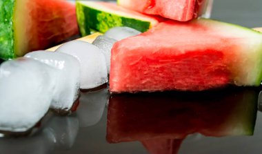 Dondurmanın içine buz küp yakın çekim yansıma koyu arka plan üzerinde ile bir sopa dilim karpuz kestim