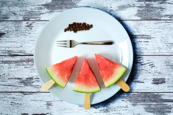 dondurma çatal yakın bir eski vintage ahşap masa üzerinde beyaz plaka üzerinde çekim ile bir sopa dilim karpuz kestim