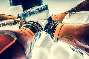 Soda buzdolabında buz üzerinde bir açık renkli cam şişelerde.  