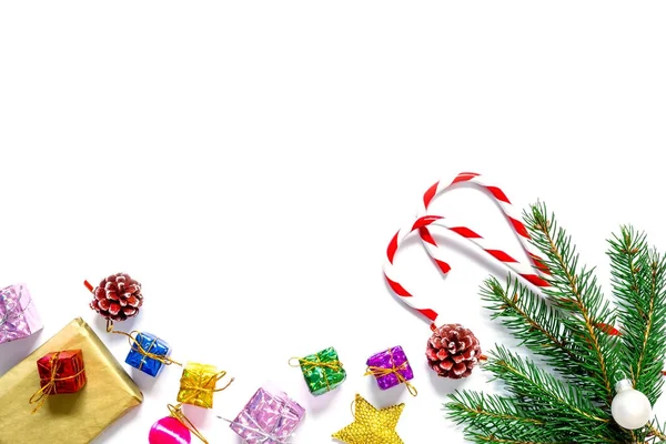 Rama de un árbol de Navidad con bolas, conos de abeto, dulces tradicionales y cajas con regalos aislados sobre fondo blanco.Fondo de Navidad y Año Nuevo . —  Fotos de Stock