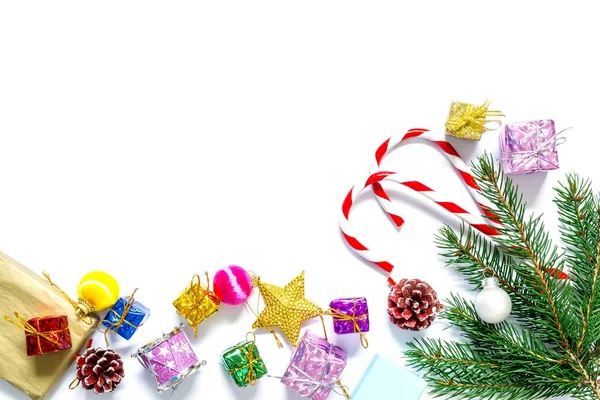 Rama de un árbol de Navidad con bolas, conos de abeto, dulces tradicionales y cajas con regalos aislados sobre fondo blanco.Fondo de Navidad y Año Nuevo . —  Fotos de Stock