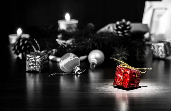Neujahrsgeschenke auf einem Holztisch mit Kerzen und einem Weihnachtsbaum mit Zapfen. vintage, Grunge alten Retro-Stil. — Stockfoto