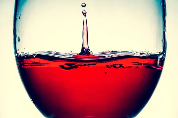 Rode wijn plons in het wijnglas close-up macro textuur achtergrond. Vintage oude retro stijl, weergave. — Stockfoto
