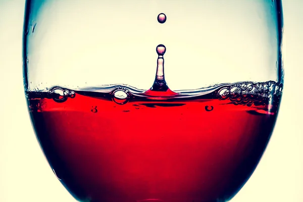 Rött vin splash i vinglas närbild makro textur bakgrunden. Vintage gamla retro stil Visa. — Stockfoto