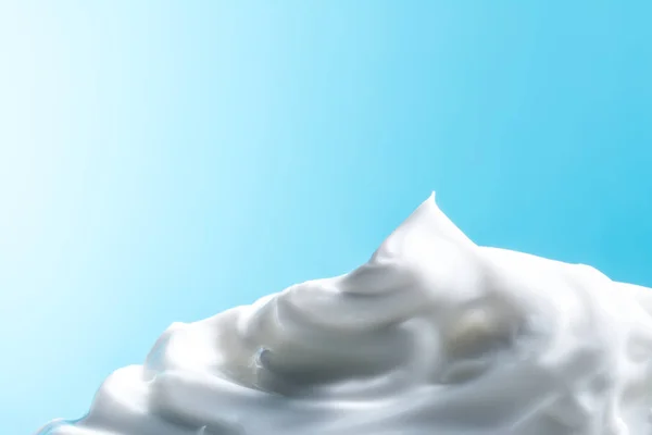 Bianco crema cosmetica primo piano macro texture su sfondo blu — Foto Stock