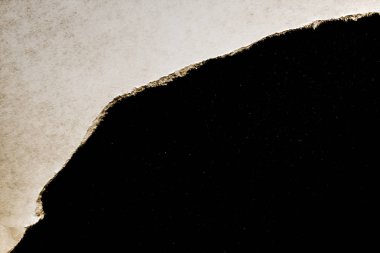 Yırtık kenarlı yırtık bir kağıt parçası içinde siyah bir arka plan ve evrendeki renkli uzay yıldızları. Kâinat manzaralı kağıt üzerinde bir delik..