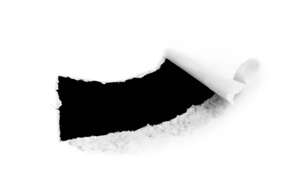 Gat in wit papier met gescheurde randen geïsoleerd op een witte achtergrond met een zwarte geïsoleerde achtergrond binnenin. — Stockfoto
