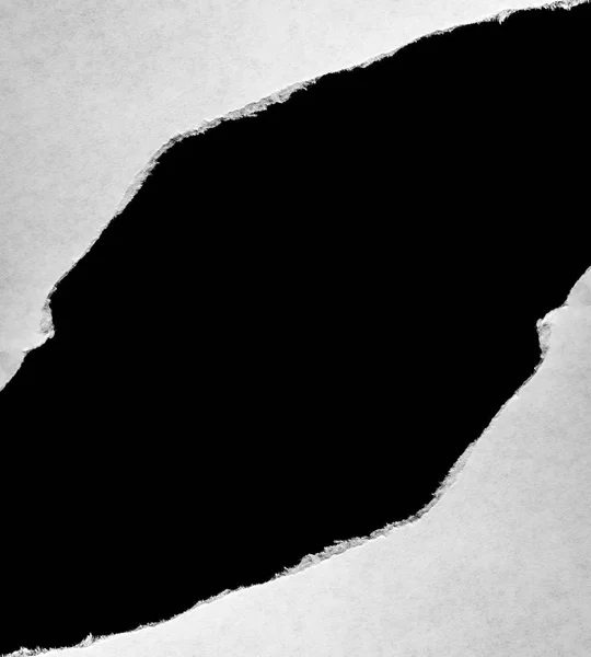 Wit papier met gescheurde randen met een zwarte geïsoleerde achtergrond binnenin. — Stockfoto