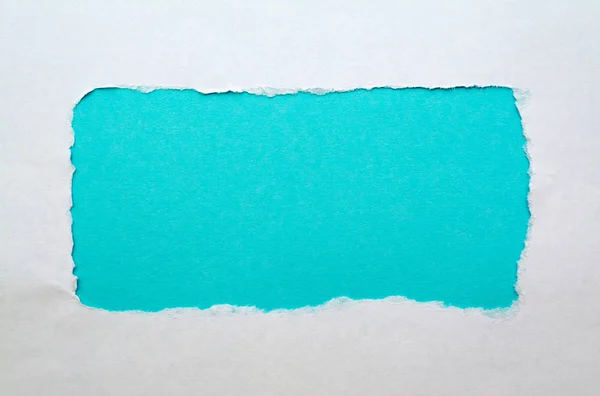 Ein Loch in weißem Papier mit abgerissenen Kanten mit hellblauem Papierhintergrund. gute Papierstruktur. — Stockfoto